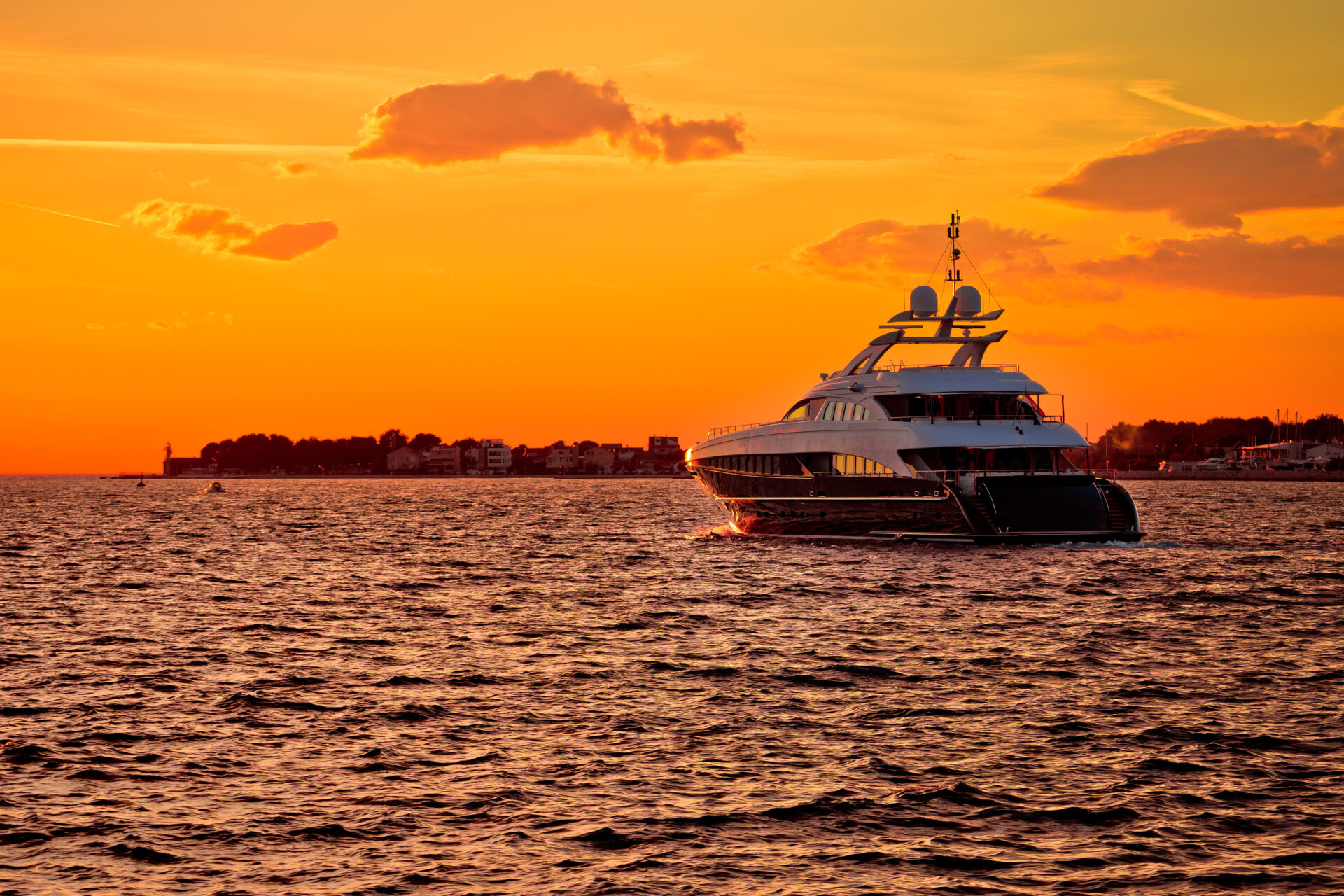Luxury yacht on open sea at golden sunset